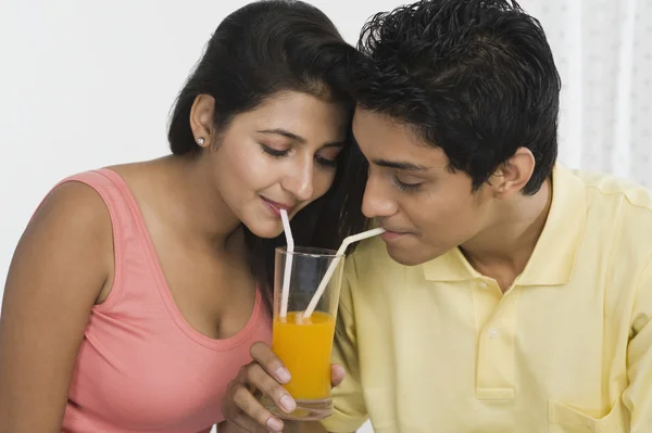 Couple sharing juice from a glass — Stock Photo, Image