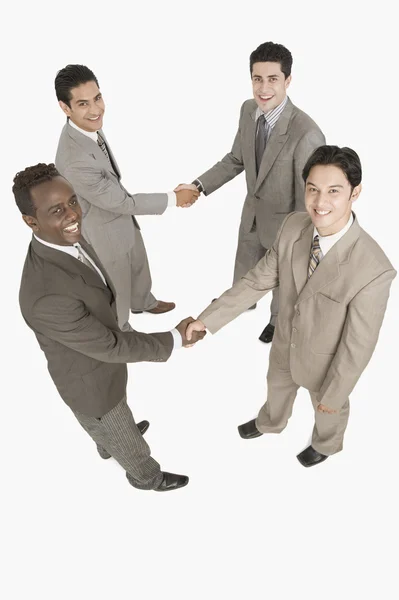 Cuatro hombres de negocios estrechando la mano — Foto de Stock