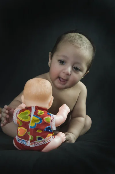 Baby boy playing with a doll — Stock Photo, Image