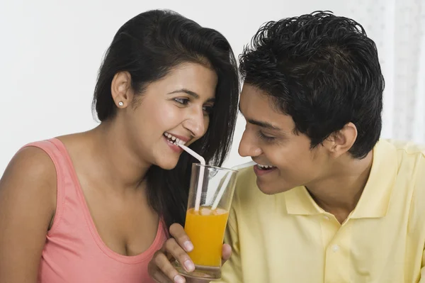 Пара ділиться соком зі склянки — стокове фото