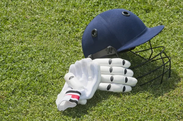 Cricket helm en handschoenen batting — Stockfoto