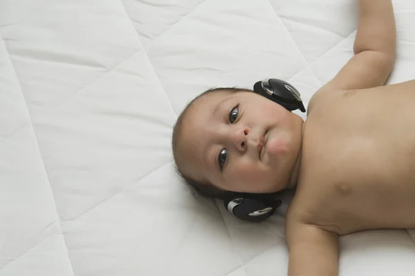 Chlapeček poslechu sluchátka — Stock fotografie