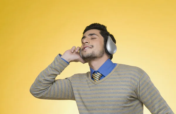 Businessman listening to headphones — Stock Photo, Image