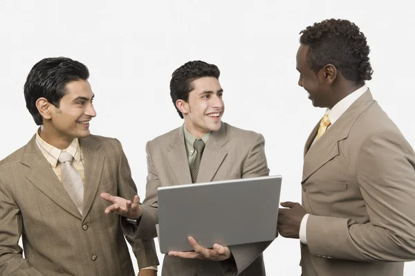 Три бизнесмена с ноутбуком — стоковое фото