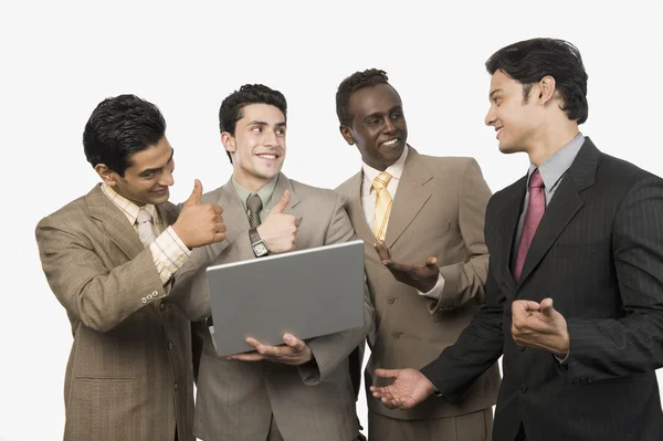 Empresarios sonriendo frente a un portátil — Foto de Stock