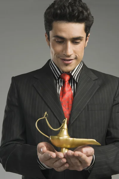 Homme d'affaires tenant une lampe magique — Photo