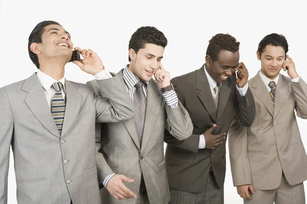 Cuatro hombres de negocios hablando en teléfonos móviles — Foto de Stock