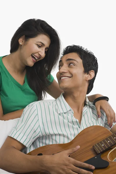 Homem tocando guitarra ao lado de uma mulher — Fotografia de Stock