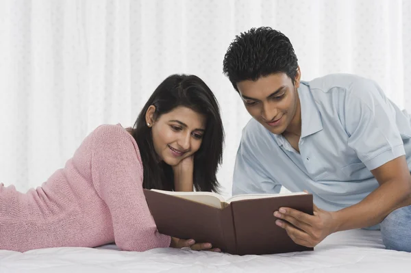 Couple lisant un livre sur le lit — Photo