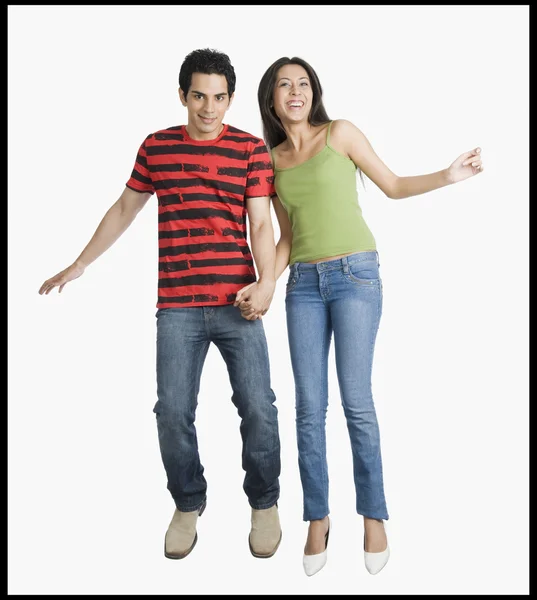 Couple jumping with holding hands on a trampoline — Stock Photo, Image