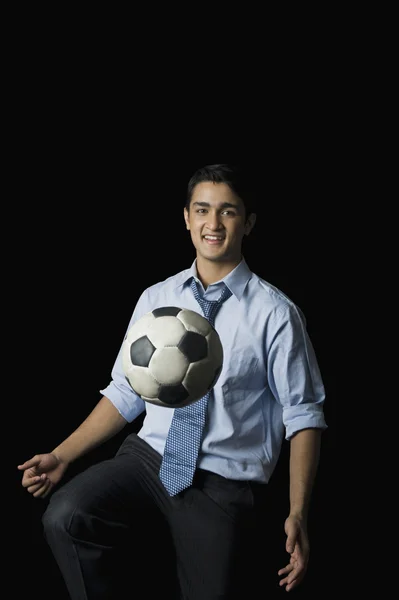 Empresário jogando com uma bola de futebol — Fotografia de Stock