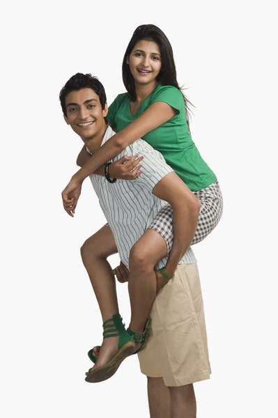 Woman riding piggyback on a man — Stock Photo, Image