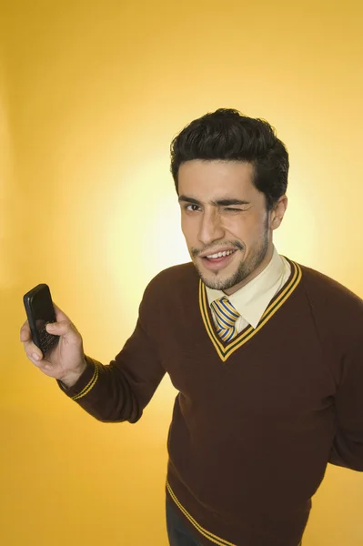 Empresario usando un teléfono móvil y guiñando un ojo — Foto de Stock