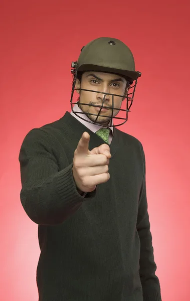 Empresario con casco de cricket y señalando — Foto de Stock