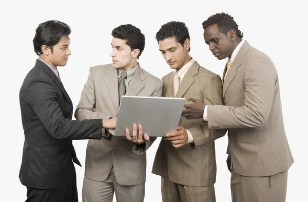 Бизнесмены, стоящие с ноутбуком — стоковое фото