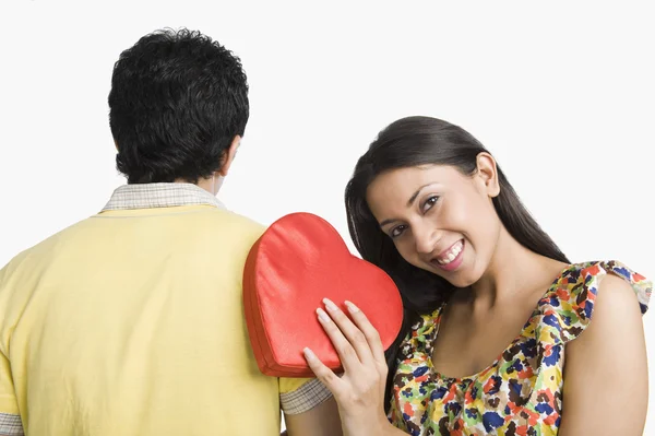 Vrouw leunend op een man en een cadeautje te houden — Stockfoto