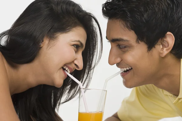 Couple sharing juice from a glass — Stock Photo, Image