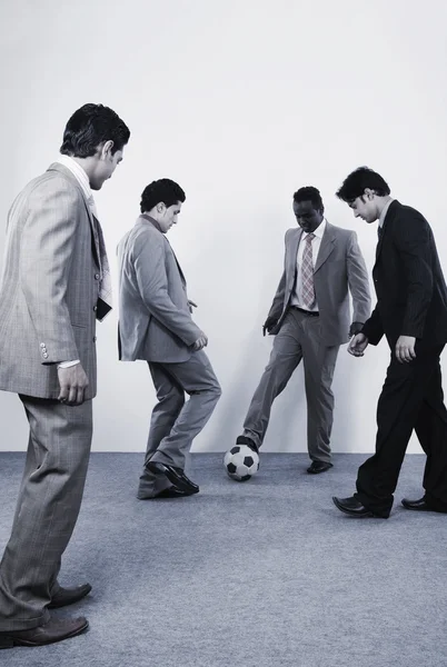 Empresários jogando com uma bola de futebol — Fotografia de Stock