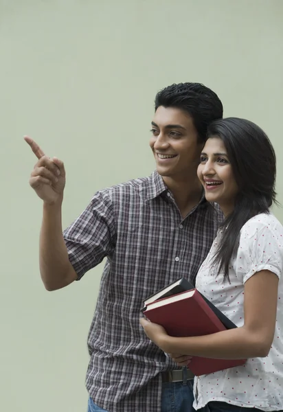 Estudiantes universitarios sosteniendo libros y sonriendo — Foto de Stock