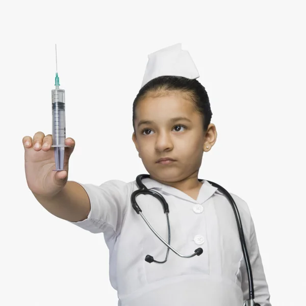 Mädchen als Krankenschwester verkleidet und mit einer Spritze in der Hand — Stockfoto