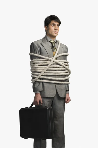 Businessman tied up with ropes and holding a briefcase — Stock Photo, Image