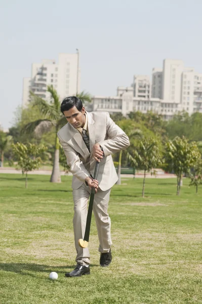 Hokey bir parkta oynarken işadamı — Stok fotoğraf