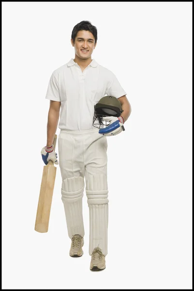 Cricket slagman promenader med en bat och hjälm — Stockfoto