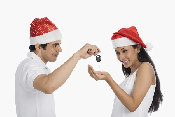 Man giving car key as a Christmas present to his girlfriend — Stock Photo, Image