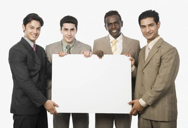 Empresarios mostrando un cartel en blanco — Foto de Stock