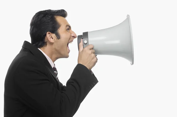 Businessman shouting into a megaphone Stock Picture