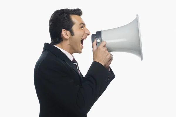 Businessman shouting into a megaphone Stock Image