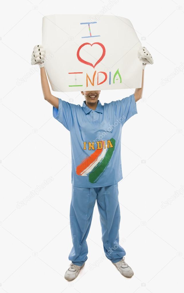 Woman in cricket uniform holding a placard