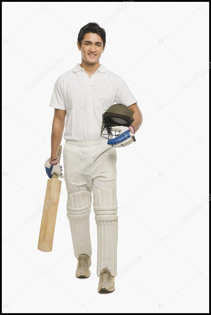 Cricket batsman walking with a bat and a helmet
