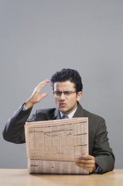işadamı bir Finansal gazete okuyor