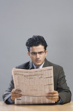 işadamı bir Finansal gazete okuyor
