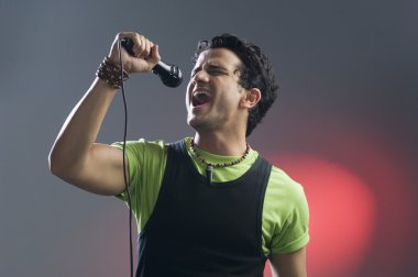 Adam mikrofona şarkı söylüyor.