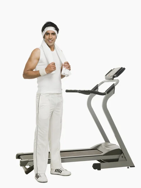 Man standing beside a treadmill — Stock Photo, Image