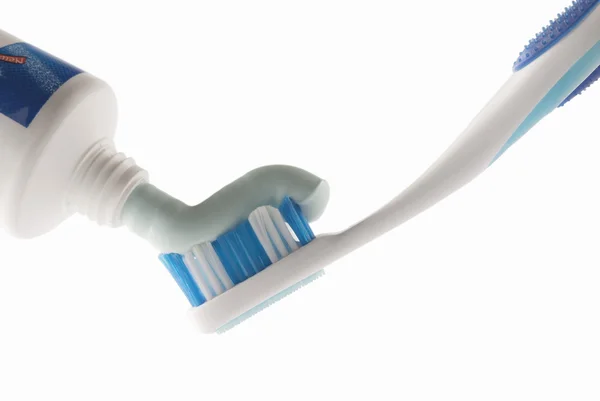 Zahnpasta wird auf Zahnbürste gepresst — Stockfoto