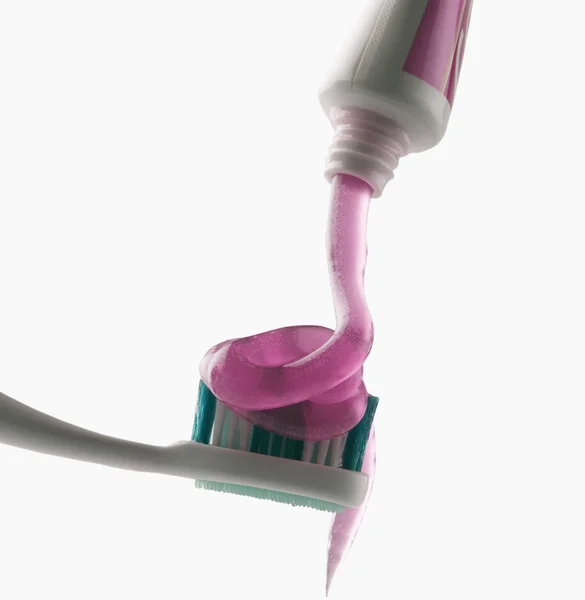 Zahnpasta wird auf Zahnbürste gepresst — Stockfoto