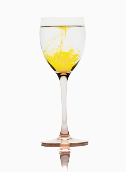 Yellow color streaks with water in a wine glass — Stock Photo, Image