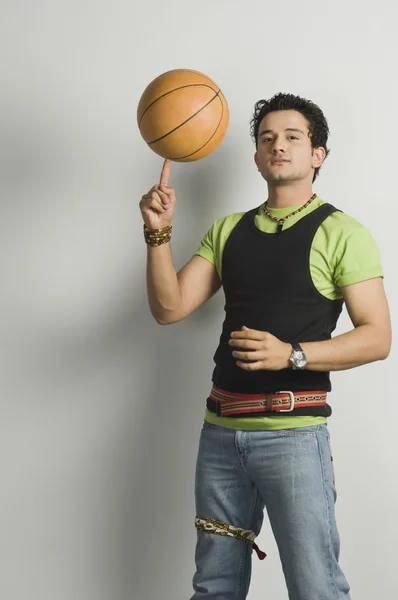 Mann balanciert Ball auf Fingerspitze — Stockfoto