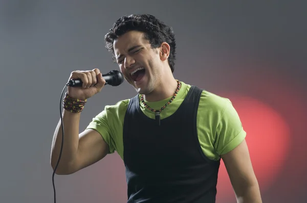 Man singing into a microphone — Stock Photo, Image