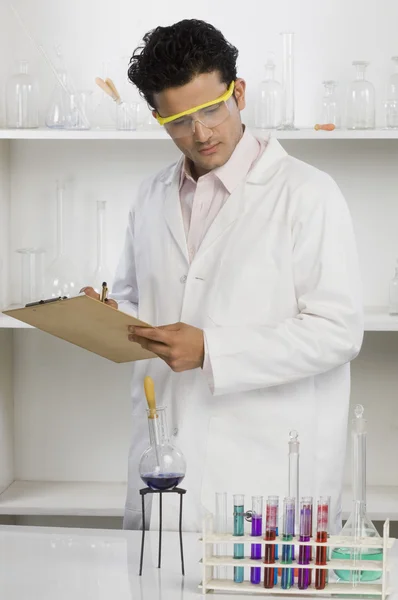 Wetenschapper schrijven op een Klembord in een laboratorium — Stockfoto