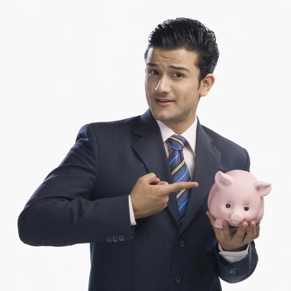 Businessman pointing at a piggy bank — Stock Photo, Image