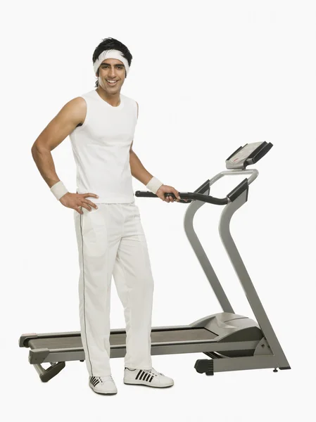 Man standing beside a treadmill — Stock Photo, Image