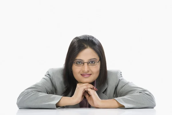 Businesswoman leaning on a table — Stock Photo, Image