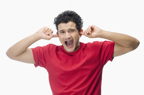 Hombre gritando con los dedos en las orejas —  Fotos de Stock