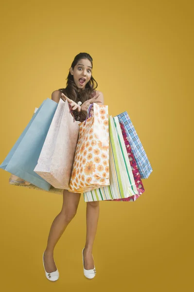 Frau zeigt Einkaufstüten und wirkt aufgeregt — Stockfoto