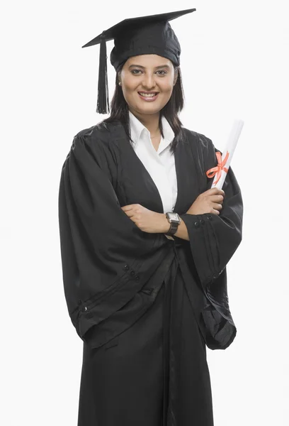 Mulher segurando um diploma em vestido de graduação — Fotografia de Stock