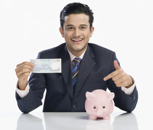 Бизнесмен, держащий банкноту — стоковое фото